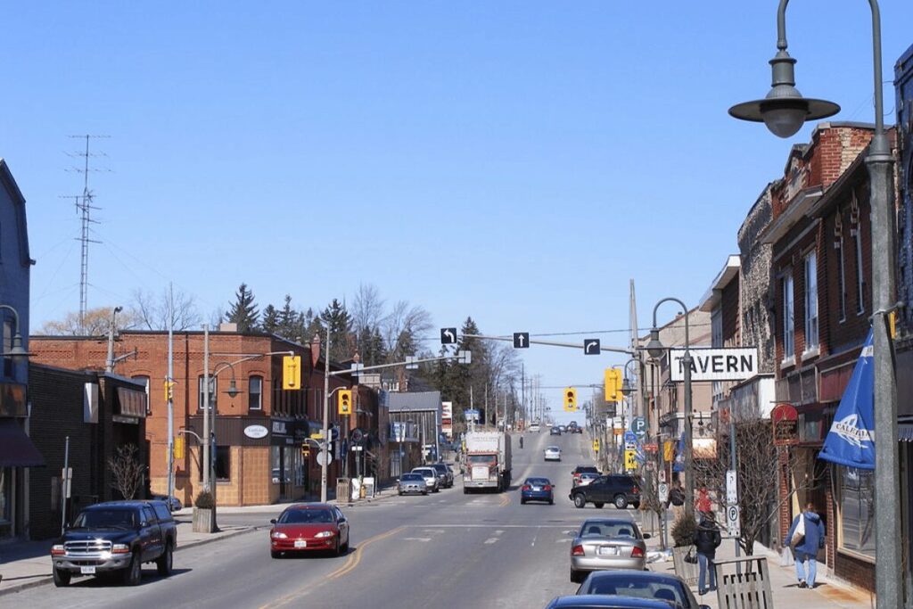 Busy Caledon main street with vehicles and storefronts on a clear day.
