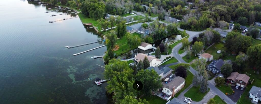 Innisfil waterfront homes and docks along green shoreline from above.