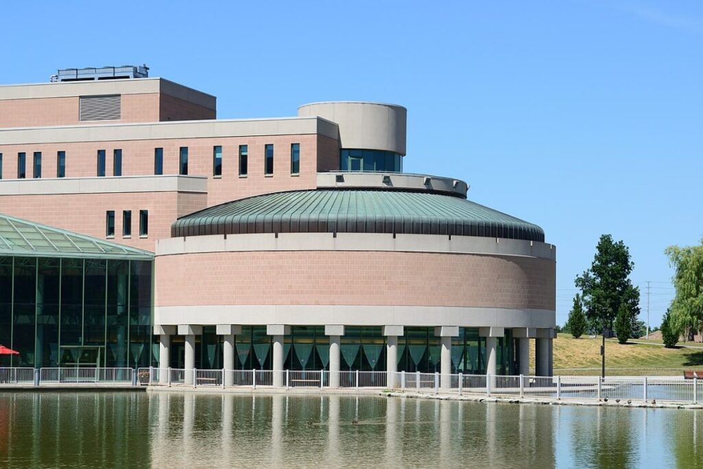 Modern civic building in Markham with water and blue sky.