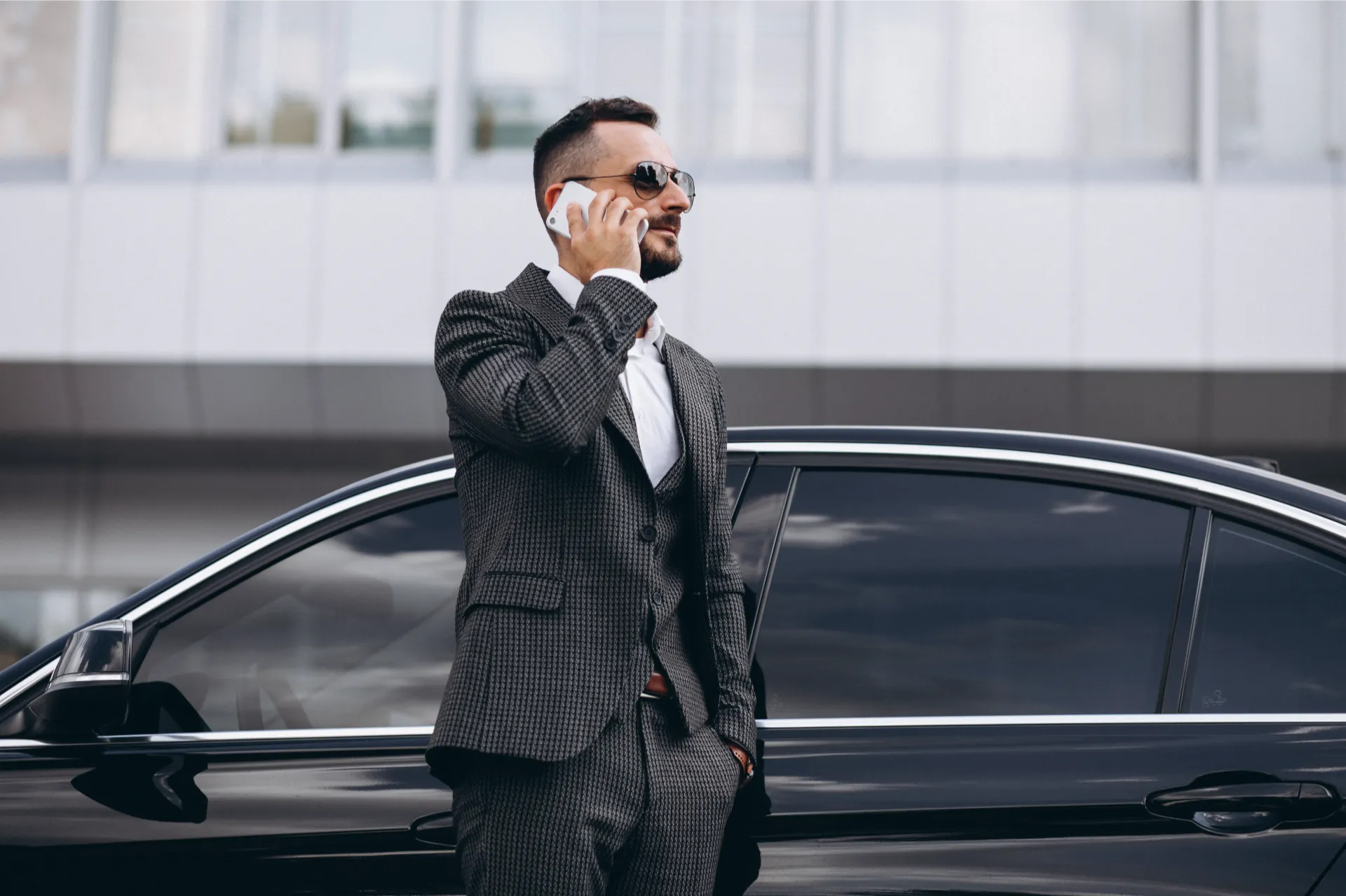 Business man by car talking phone